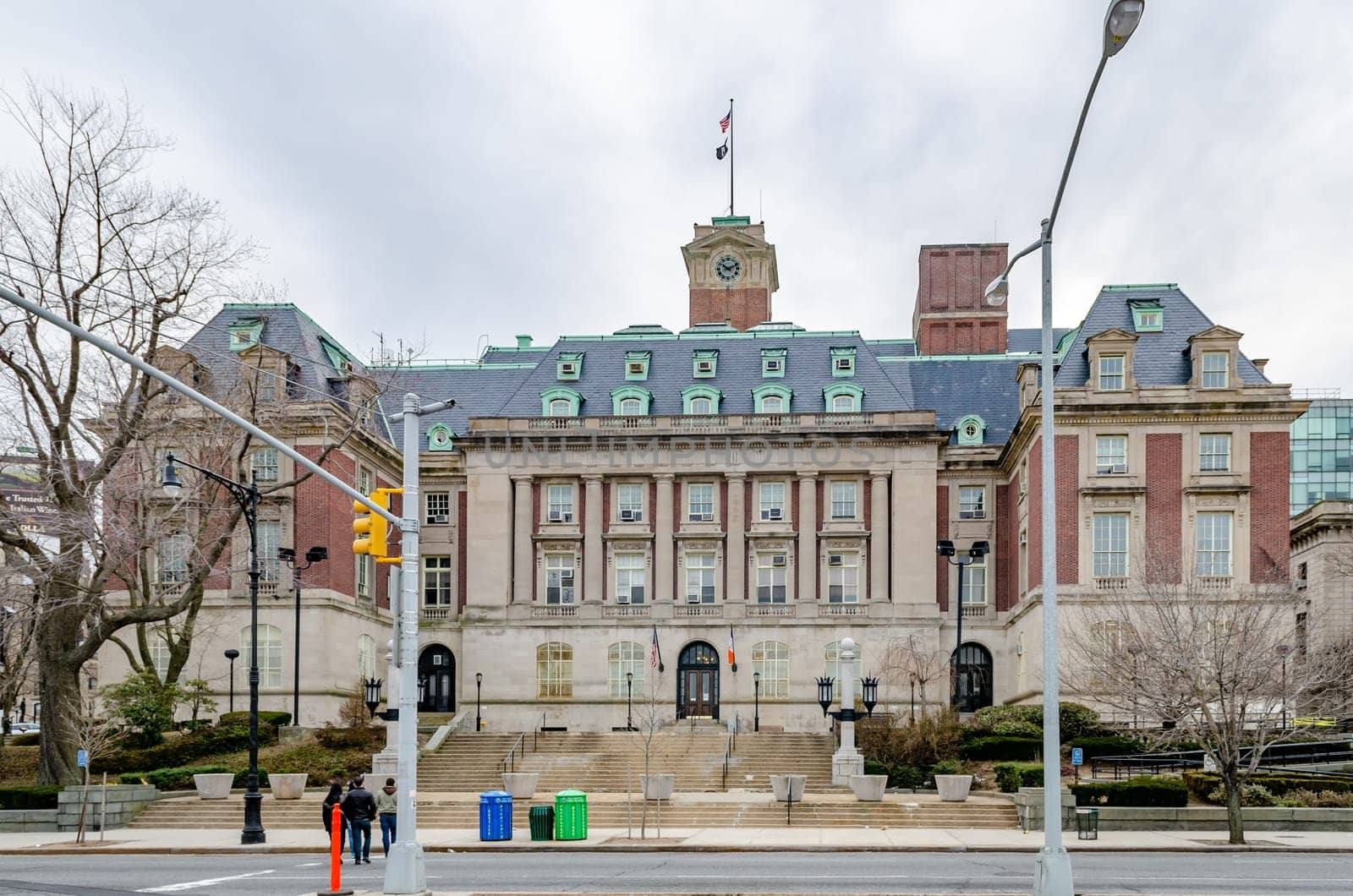 Staten Island Borough Hall with traffic lights and people crossing the street in the forefront, New York City, during winter day with overcast, horizontal