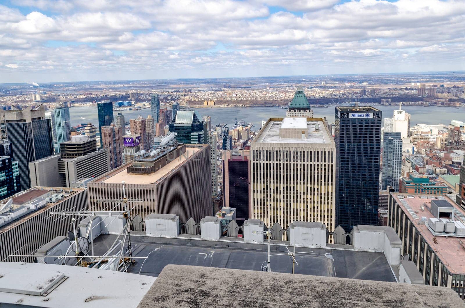 Manhattan Skyscraper in front of Hudson River, aerial view from Rockefeller Center with Allianz Tower and W Hotels Sign, during winter with beautiful cloud sky, horizontal