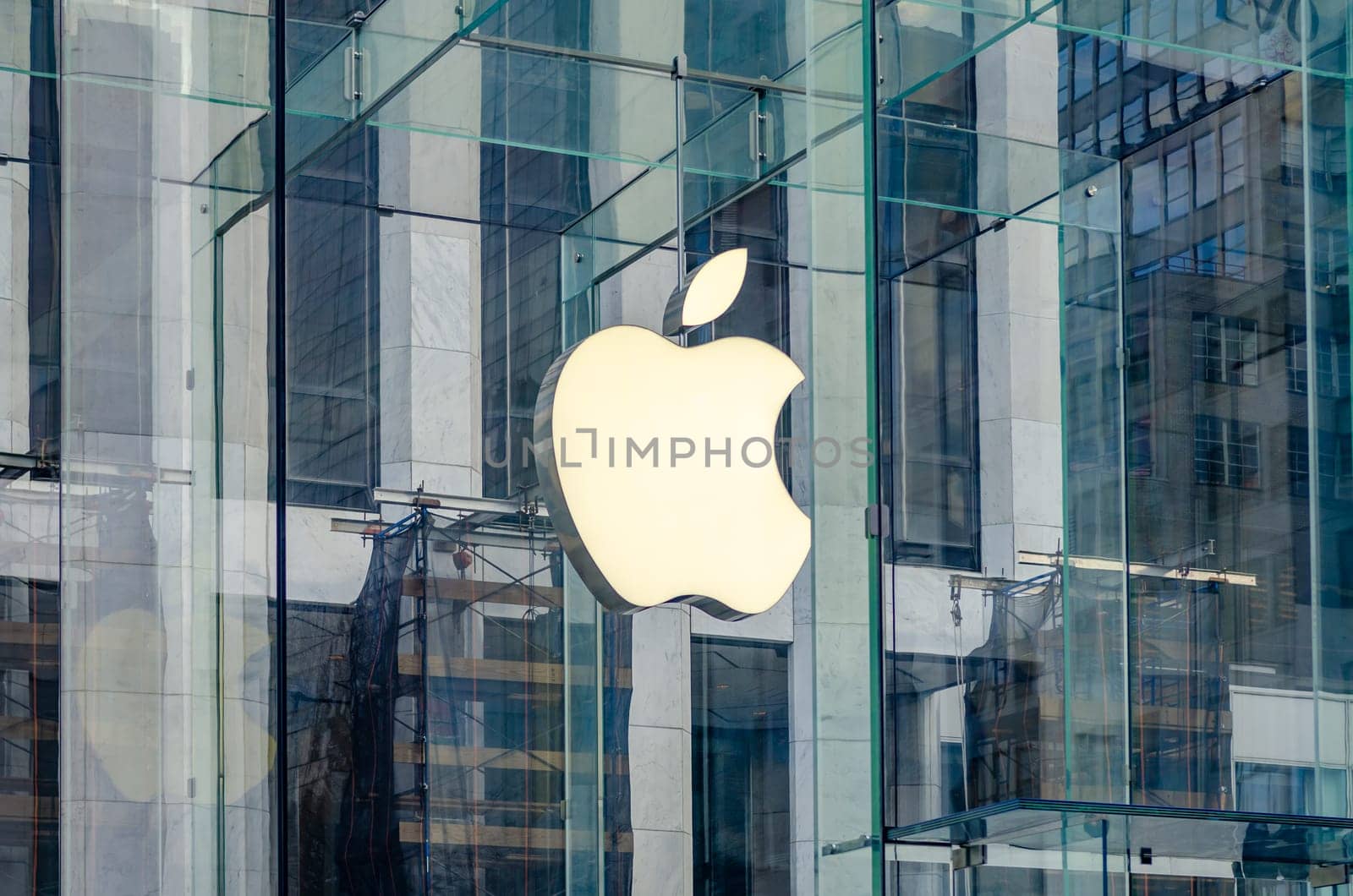 Close-up of the Apple Logo at the Apple Store in Manhattan, White apple behind glass cube, New York City during sunny winter day, horizontal