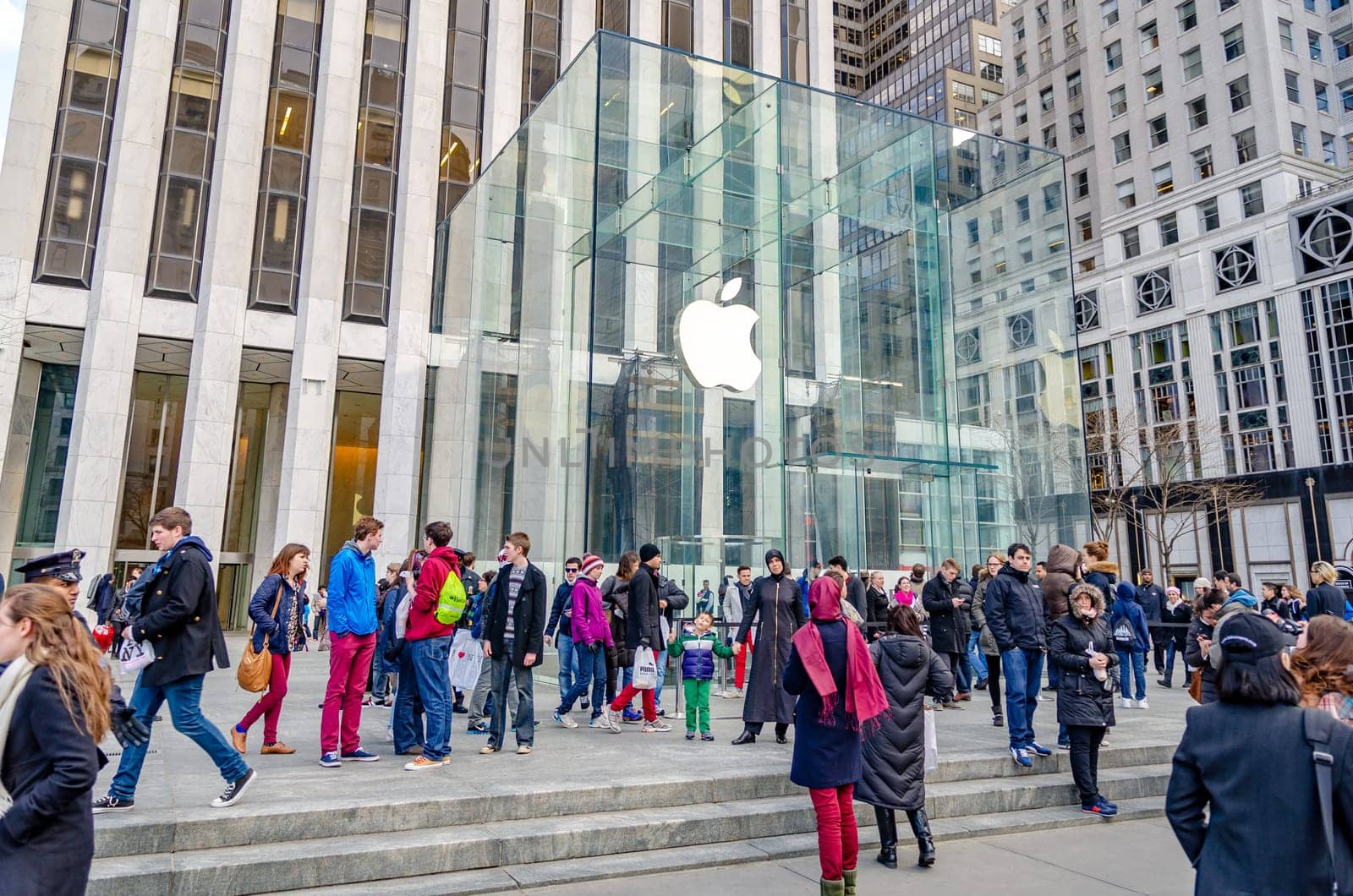 Apple Store, Manhattan, Glass Cube with white apple logo, white angle shot, New York City with lots of people walking in front during sunny winter day, horizontal