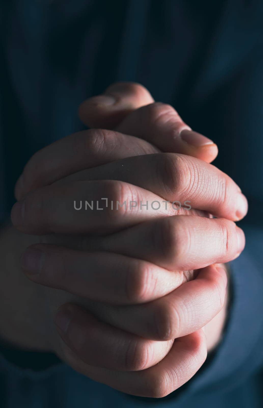 Praying hands with faith in religion and belief in God on dark background. Power of hope or love and devotion.