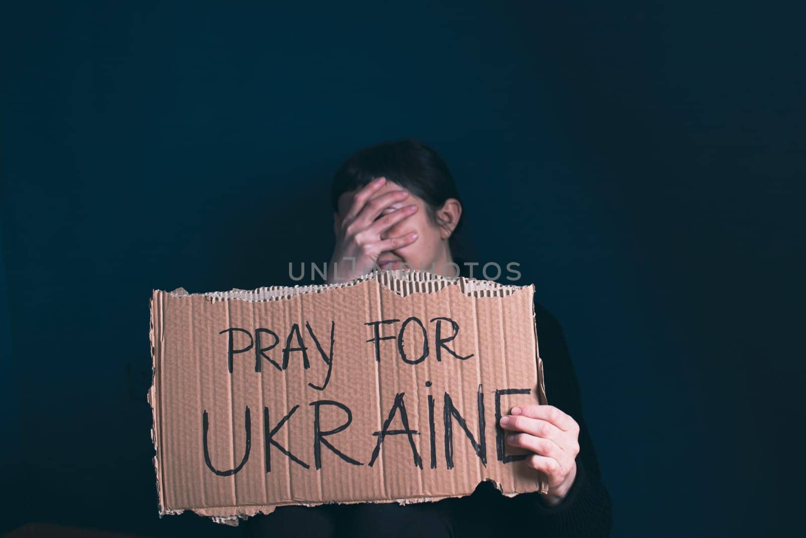 Woman holds a banner with anti-war message. Protest against the Russian intervention to Ukraine, activism and human rights movement. Concept of standing with Ukrainian.