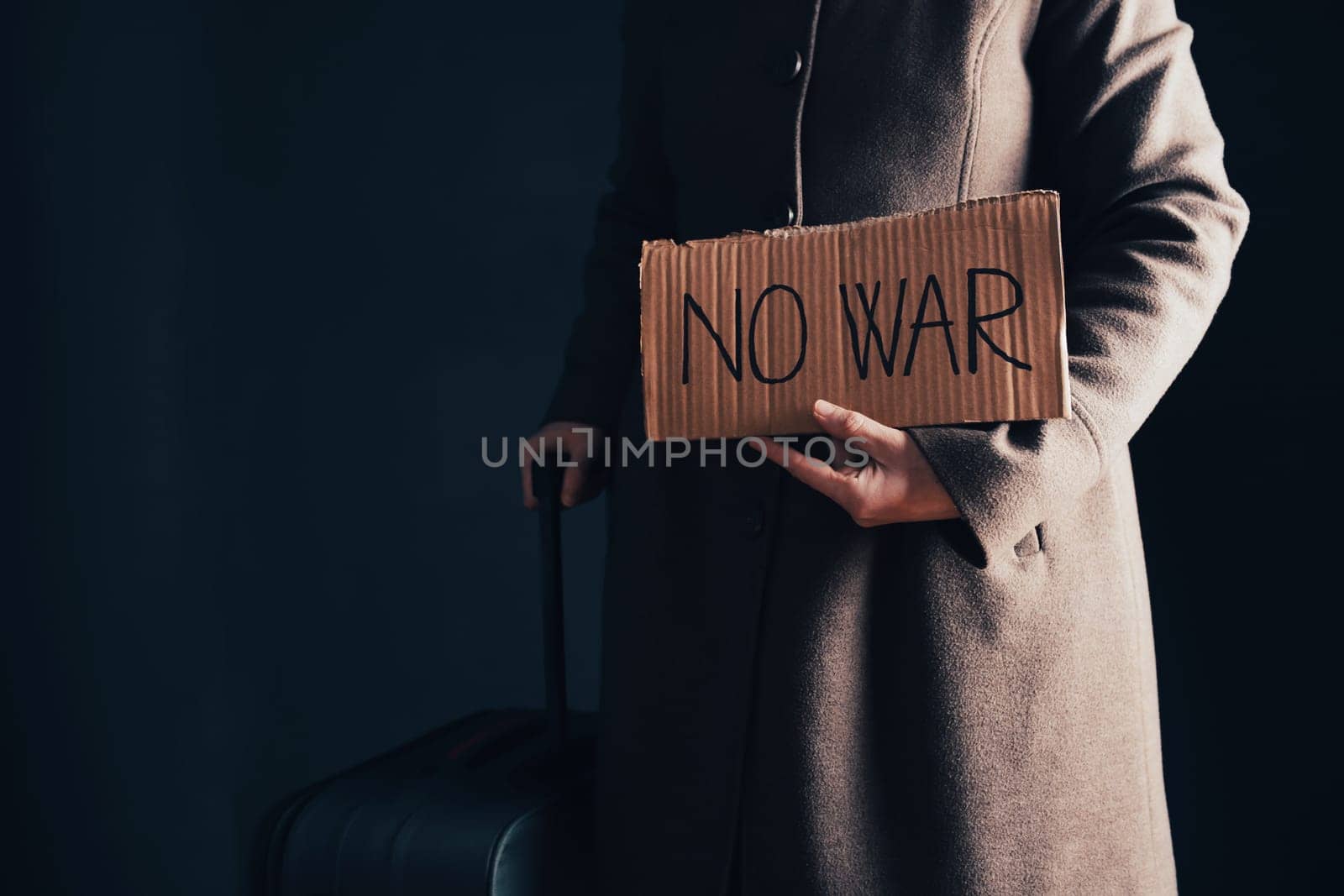 Ukrainian refugee holding placard with No war text. Evacuation of civilians. Freedom to Ukraine concept.