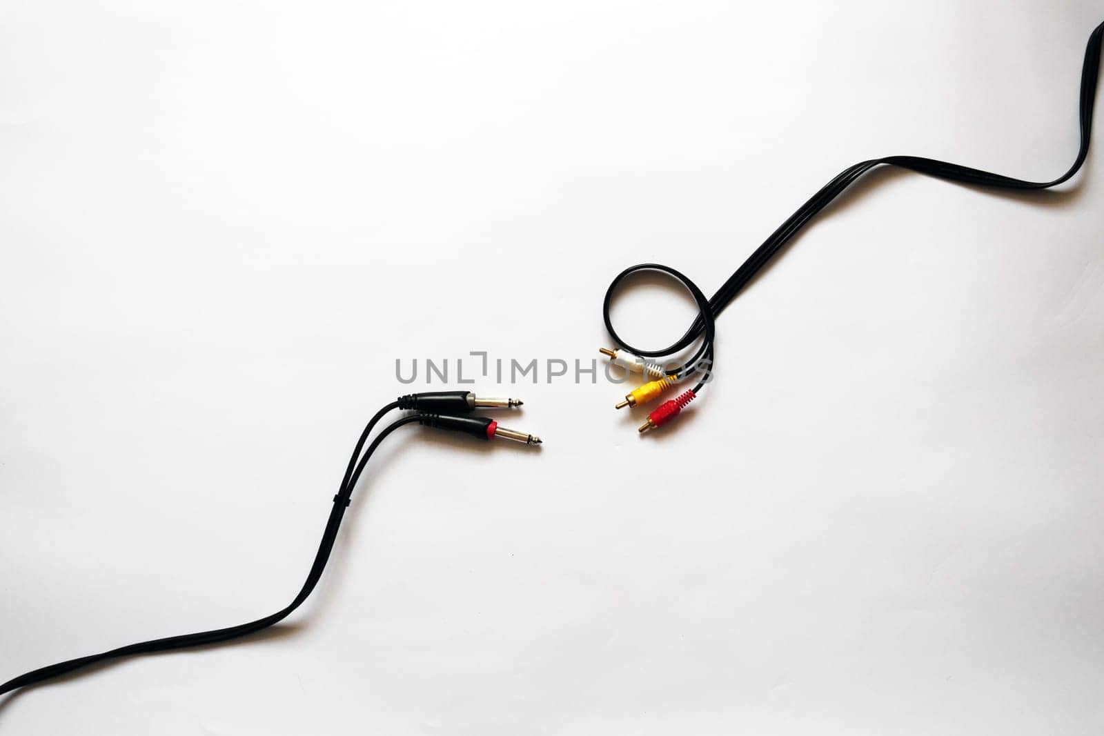 Photo on a white isolated background showing two cables for sound recording. Cord Jack 6.3 mm and RCA jack. You can use this photo as a background for projects related to audio recording, audio connection or a store with cords and cables. High quality photo