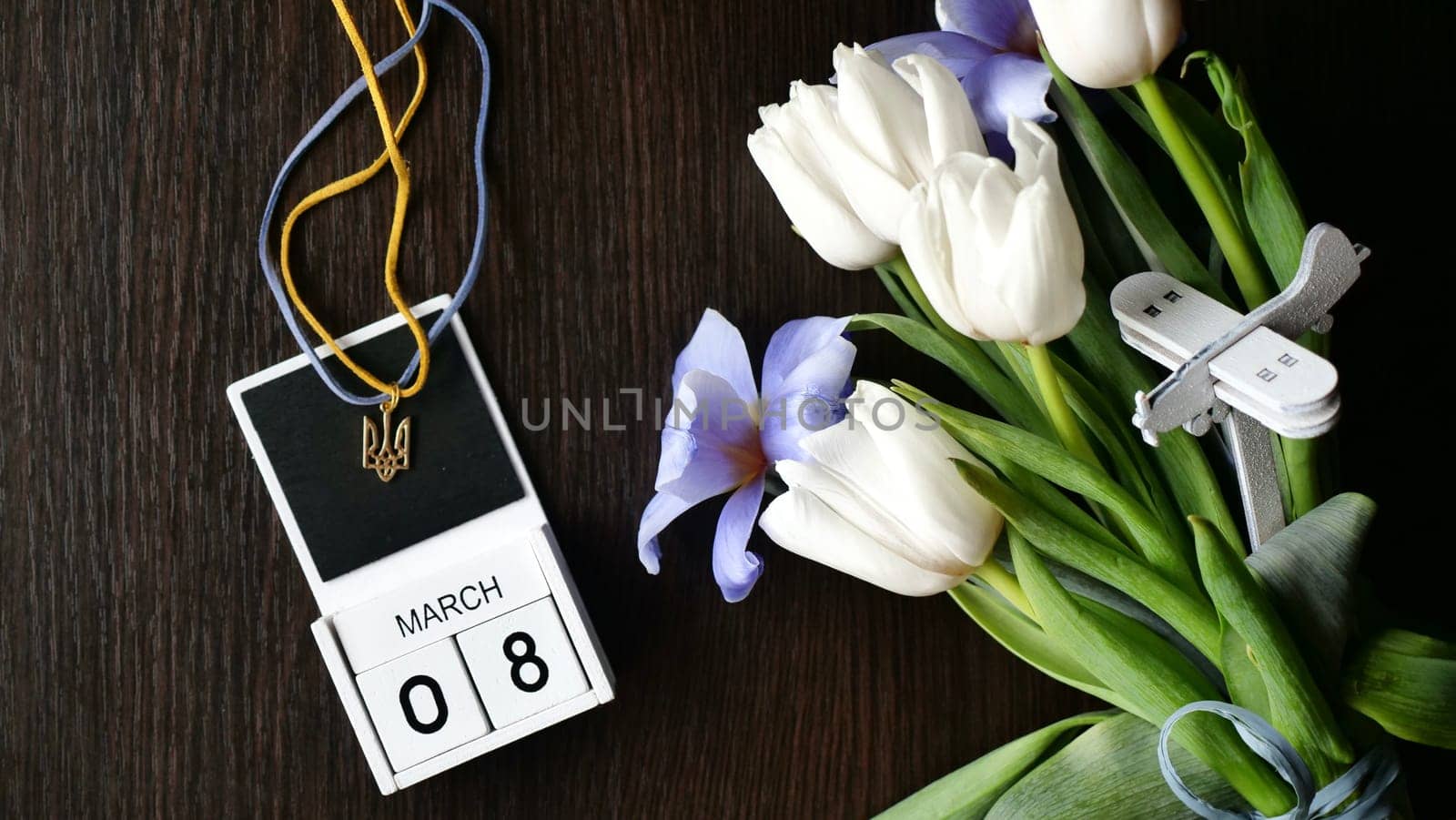 International Women's Day is March 8 on the calendar in Ukraine during the war. Spring flowers tulips - white and blue. state emblem of ukraine and the plane