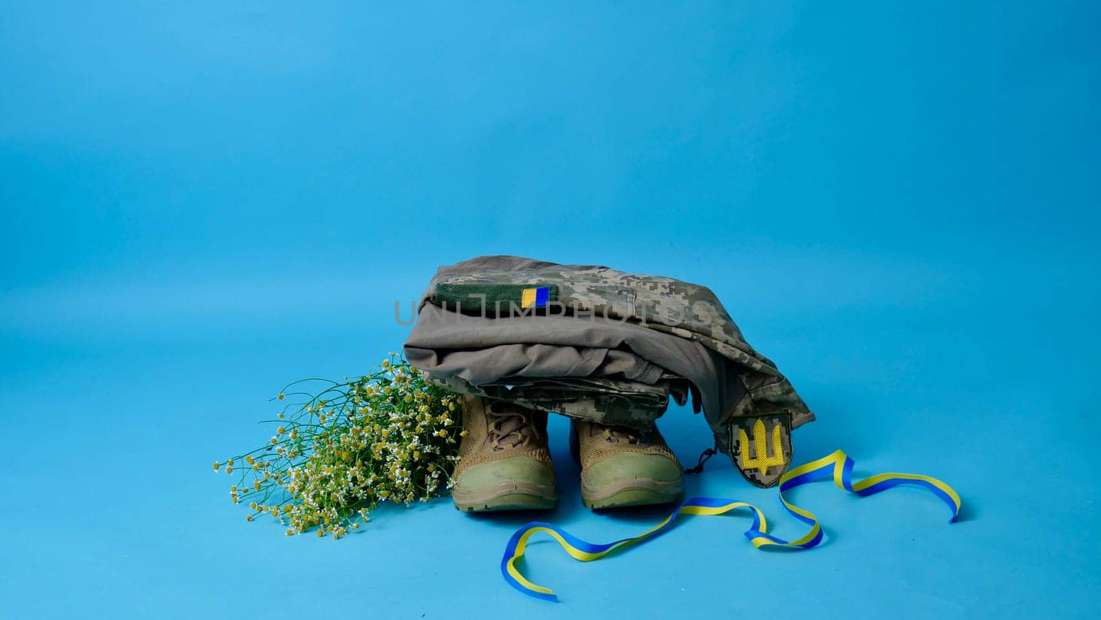 Military uniform of a Ukrainian soldier of the Armed Forces of Ukraine 2022 on an isolated blue background in a close-up studio in the war with Russia. Clothes of a true hero