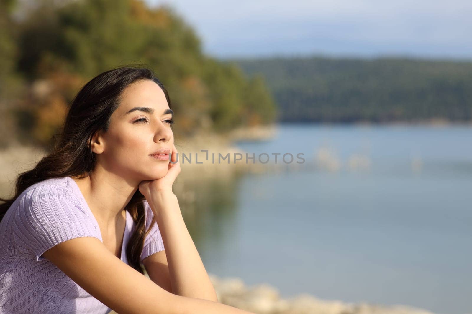 Relaxed woman contemplating lake views on vacation