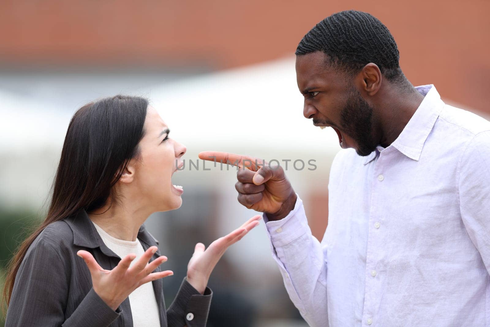 Angry man arguing and pointing to a woman