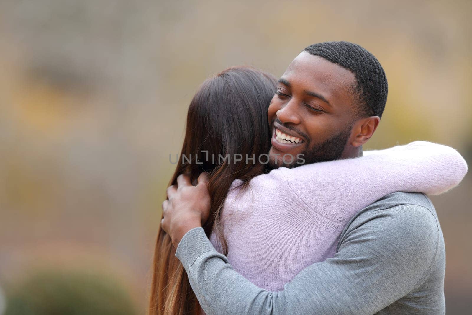 Couple hugging and happy man smiling in a park