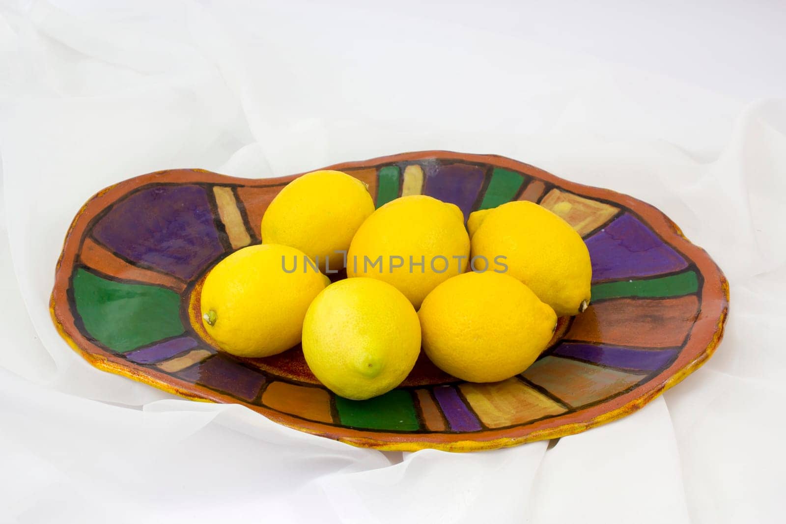 fresh lemons on a clay plate - handmade pottery