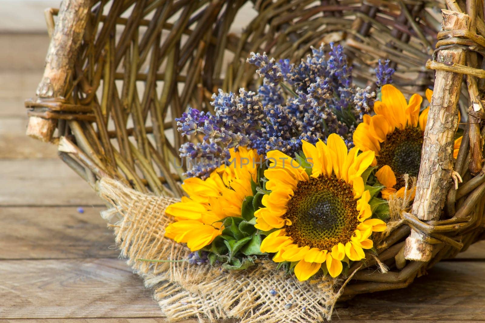 sunflowers and lavender in a basket on wooden background