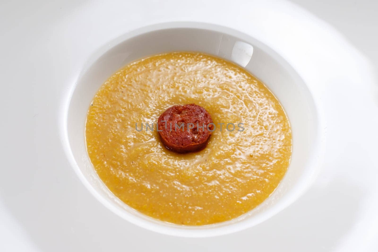 Italien polenta with parmesan cheese and chorizo sausage close-up