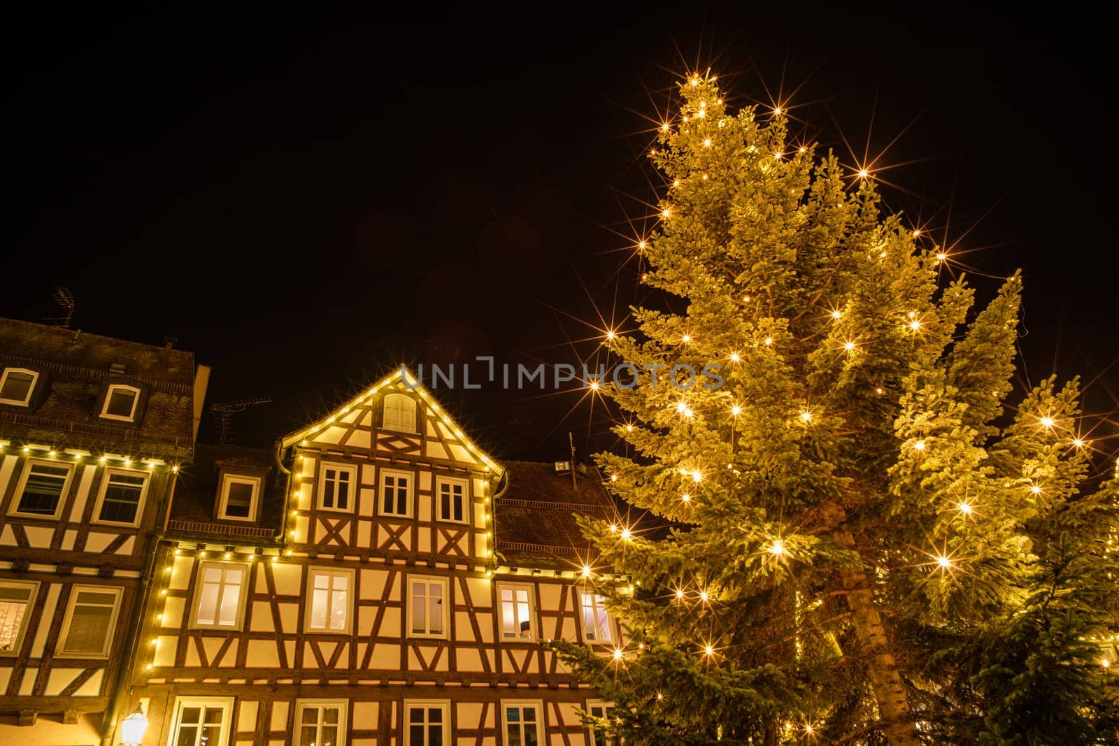 Christmas tree with lights and half-timbered house Schorndorf Germany