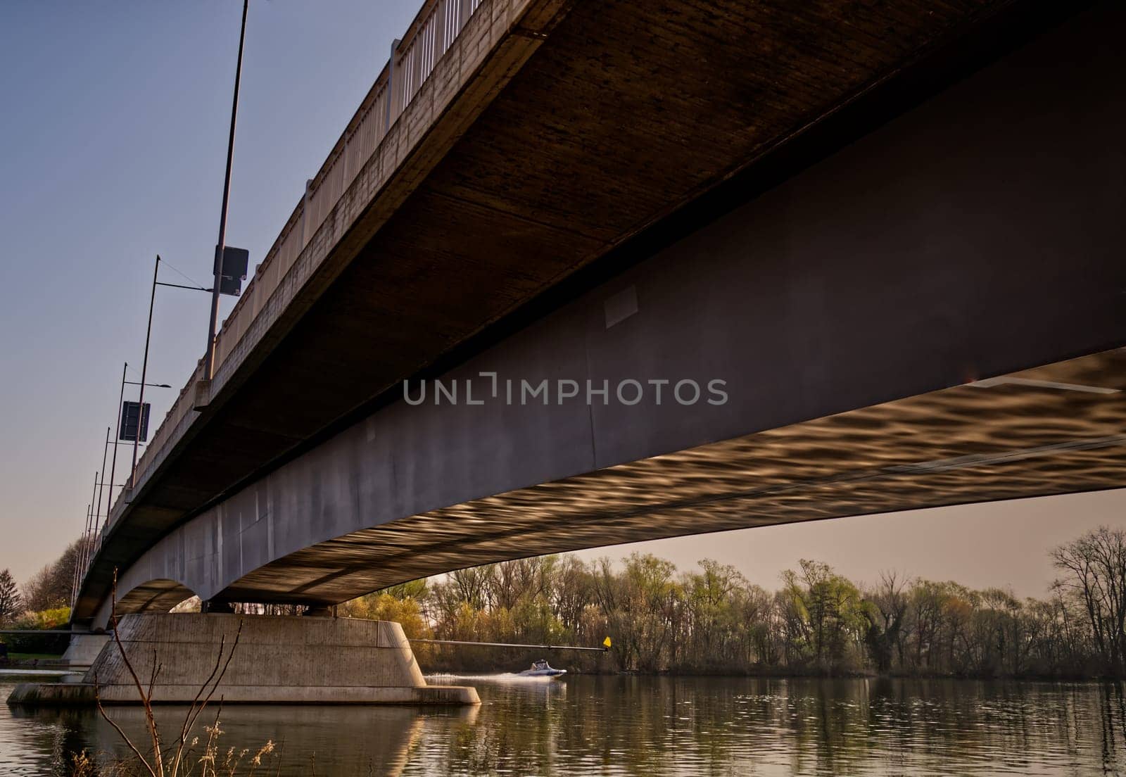 View: Bottom of the Carl-Ulrich bridge in Offenbach with atmospheric light reflections, sneeking a peek of a little motor boat on the river