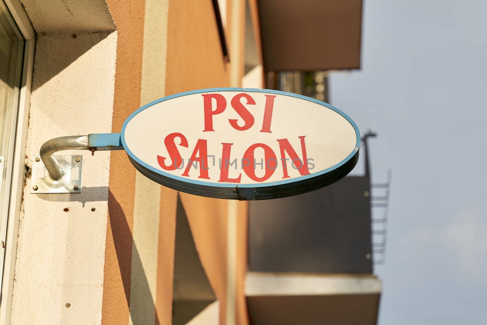 Illuminated sign with the inscription Psi Salon (pet hairdresser) in the center of Kolobrzeg in Poland