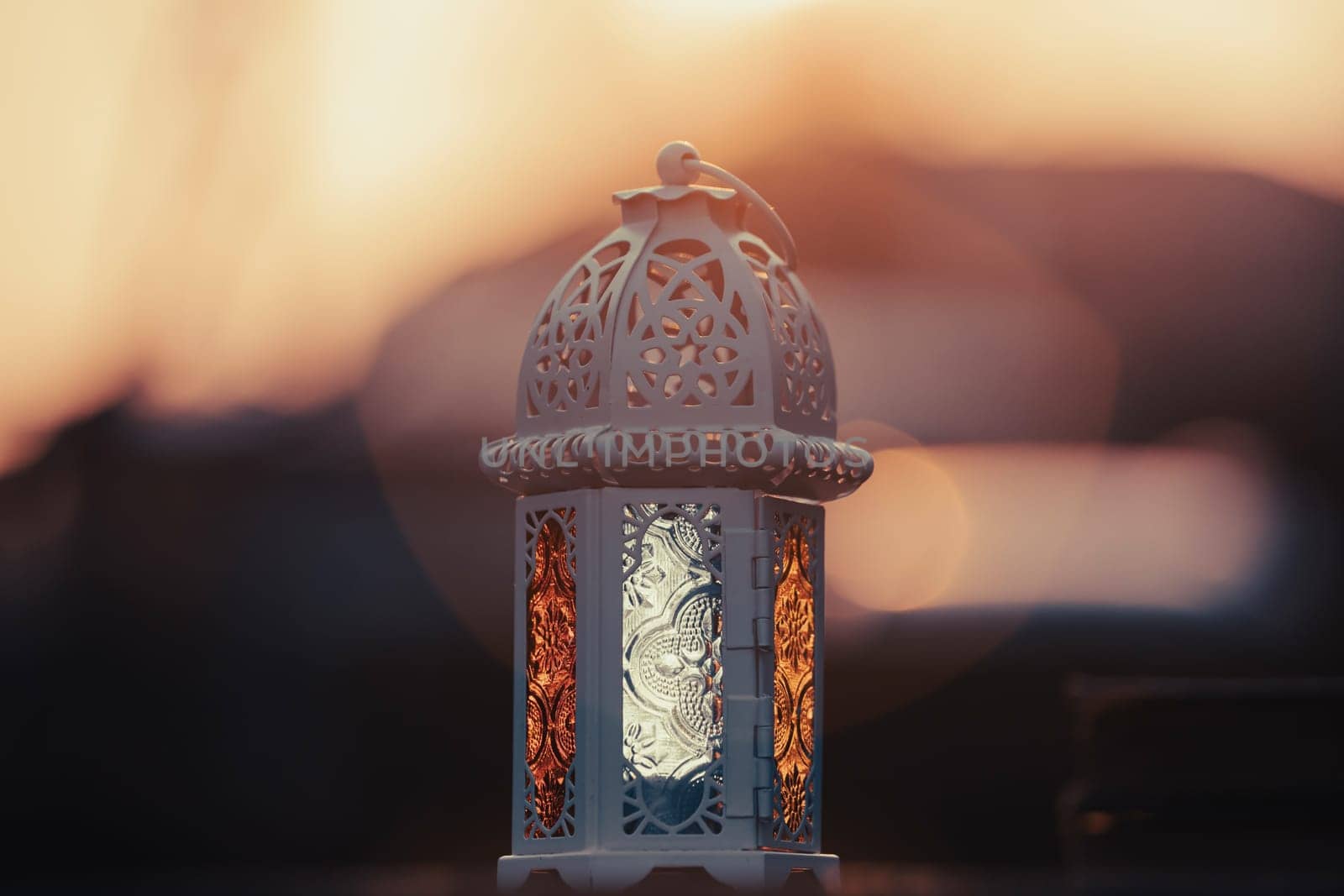 Ramadan Kareem background. Ornamental Arabic lantern glowing at night and the holy book of Quran.