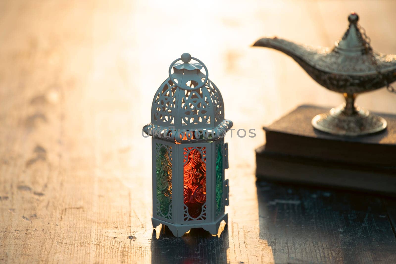 Ramadan Kareem background. Ornamental Arabic lantern glowing at night and the holy book of Quran.
