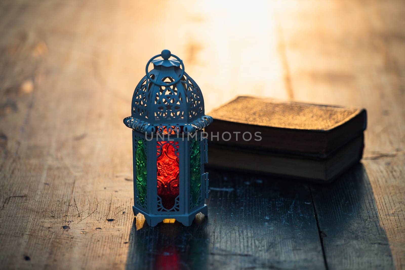 Ramadan Kareem background. Ornamental Arabic lantern glowing at night and the holy book of Quran.