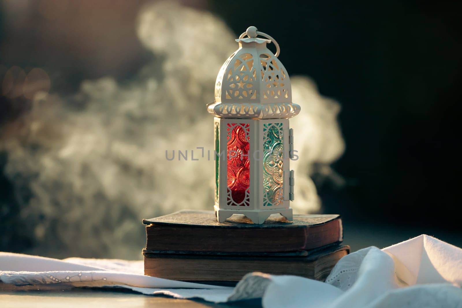 Ramadan Kareem background. Ornamental Arabic lantern glowing at night and the holy book of Quran.