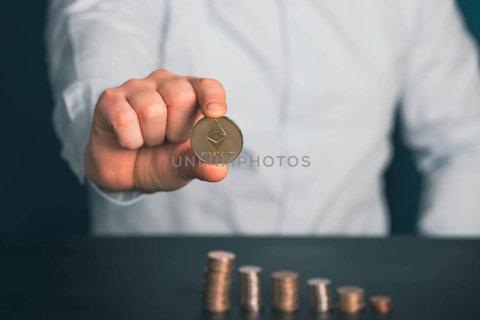 Businessman holding silver ethereum. Digital asset, cryptocurrency, metaverse, NFT concept.