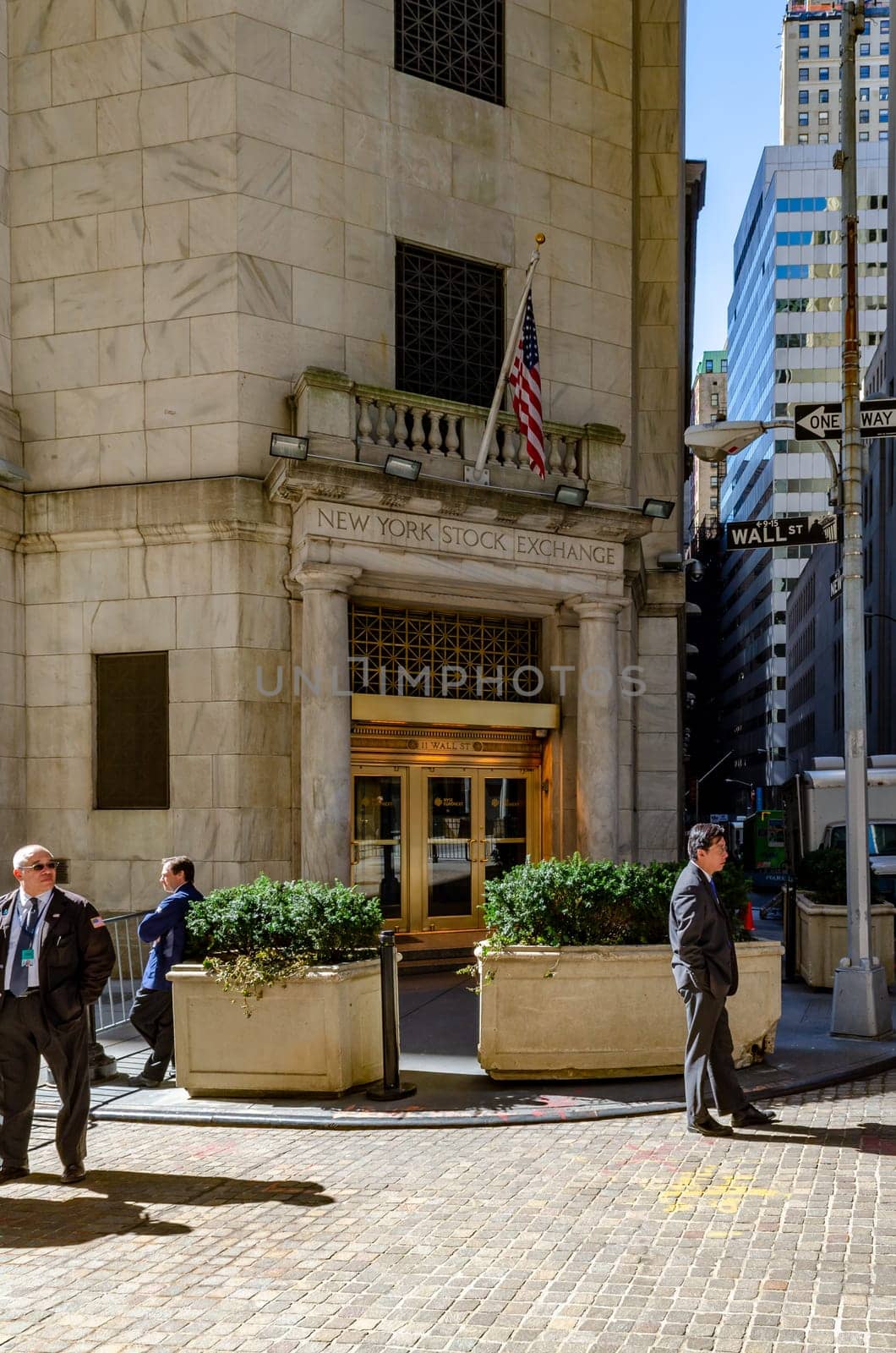 New York Stock Exchange golden colored Building Entrance with Security in suits standing in front, vertical