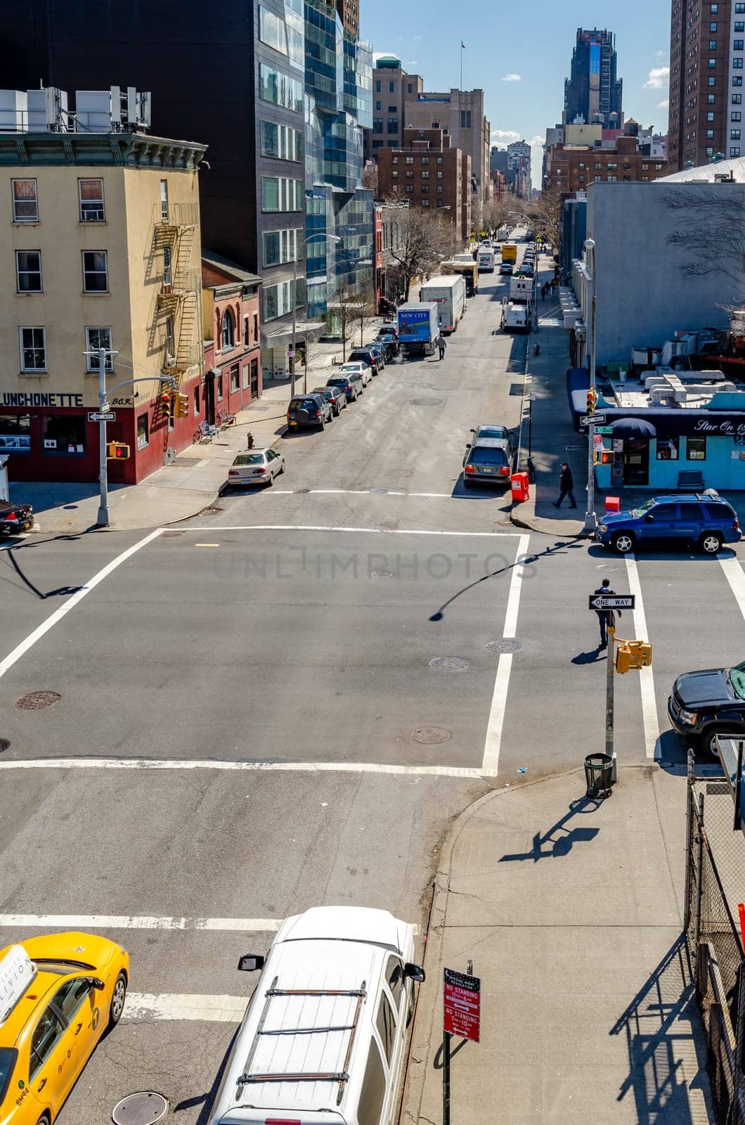 City Street crossroads with traffic, aerial view from The High Line, Chelsea, New York City during sunny winter day, vertical