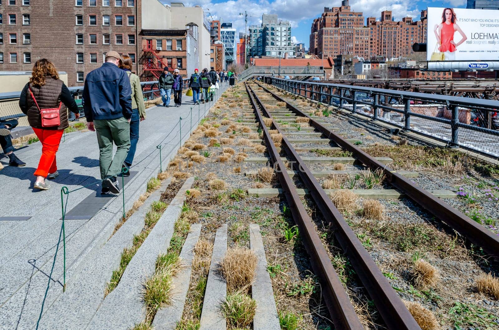 The High Line Rooftop Park, New York City with railroad track and People walking around during sunny winter day, Skyscraper around the park, horizontal