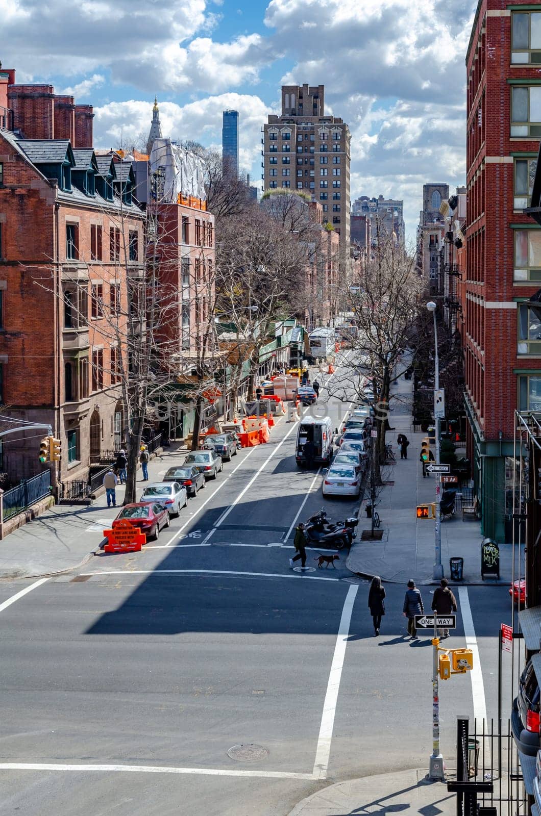 Chelsea City Street crossroads, aerial view from the High Line Rooftop Park, New York City during sunny winter day, lots of cars parked on the street vertical