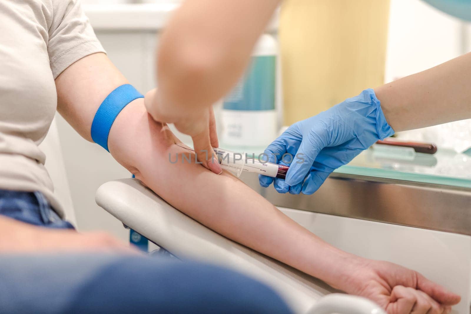Close-up Of Doctor Taking Blood Sample From Patient's Arm in Hospital for Medical Testing