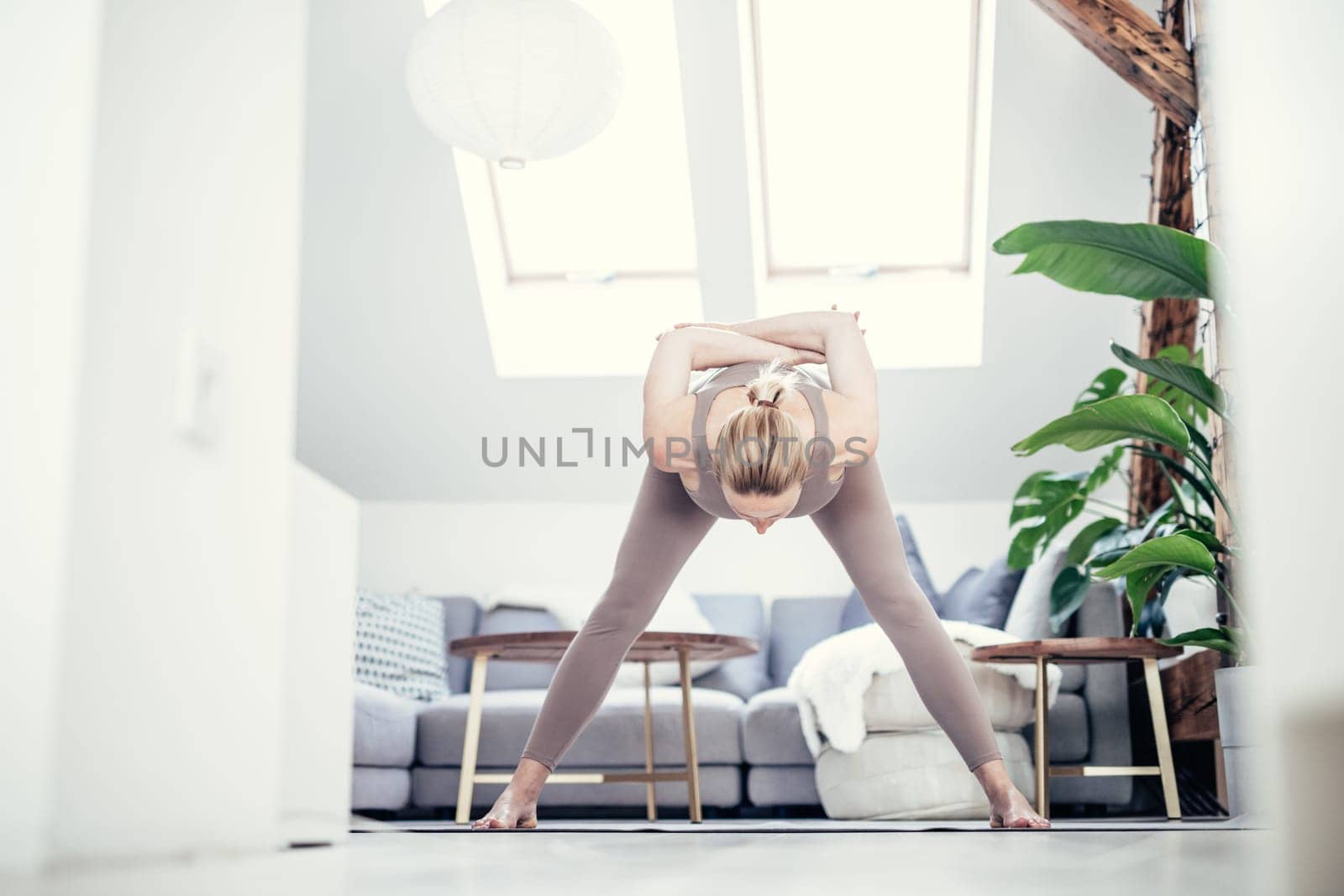 Young beautiful pregnant woman training pilates at home in her living room. Healthy lifestyle and active pregnancy and motherhood concept