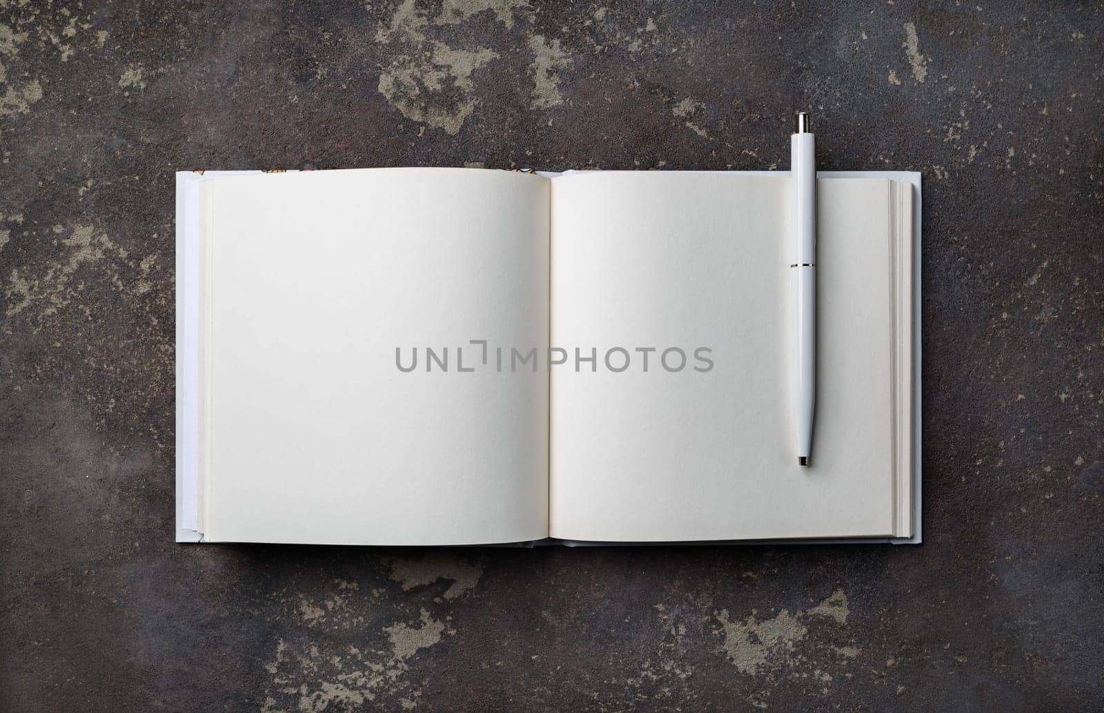 Photo of blank booklet and pen on concrete background. Responsive design mockup. Flat lay.