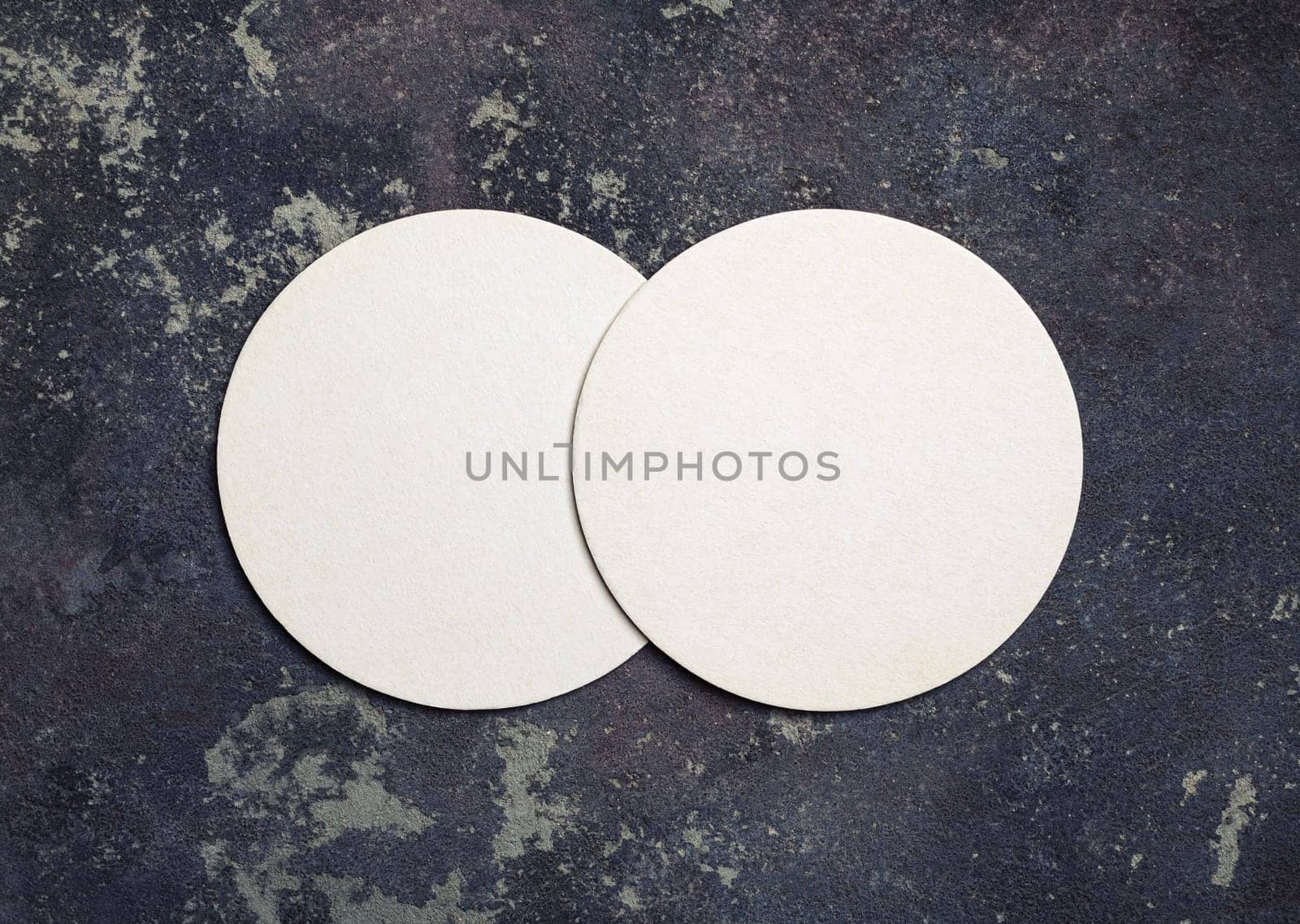 Photo of two blank beer coasters on concrete background. Top view. Flat lay.