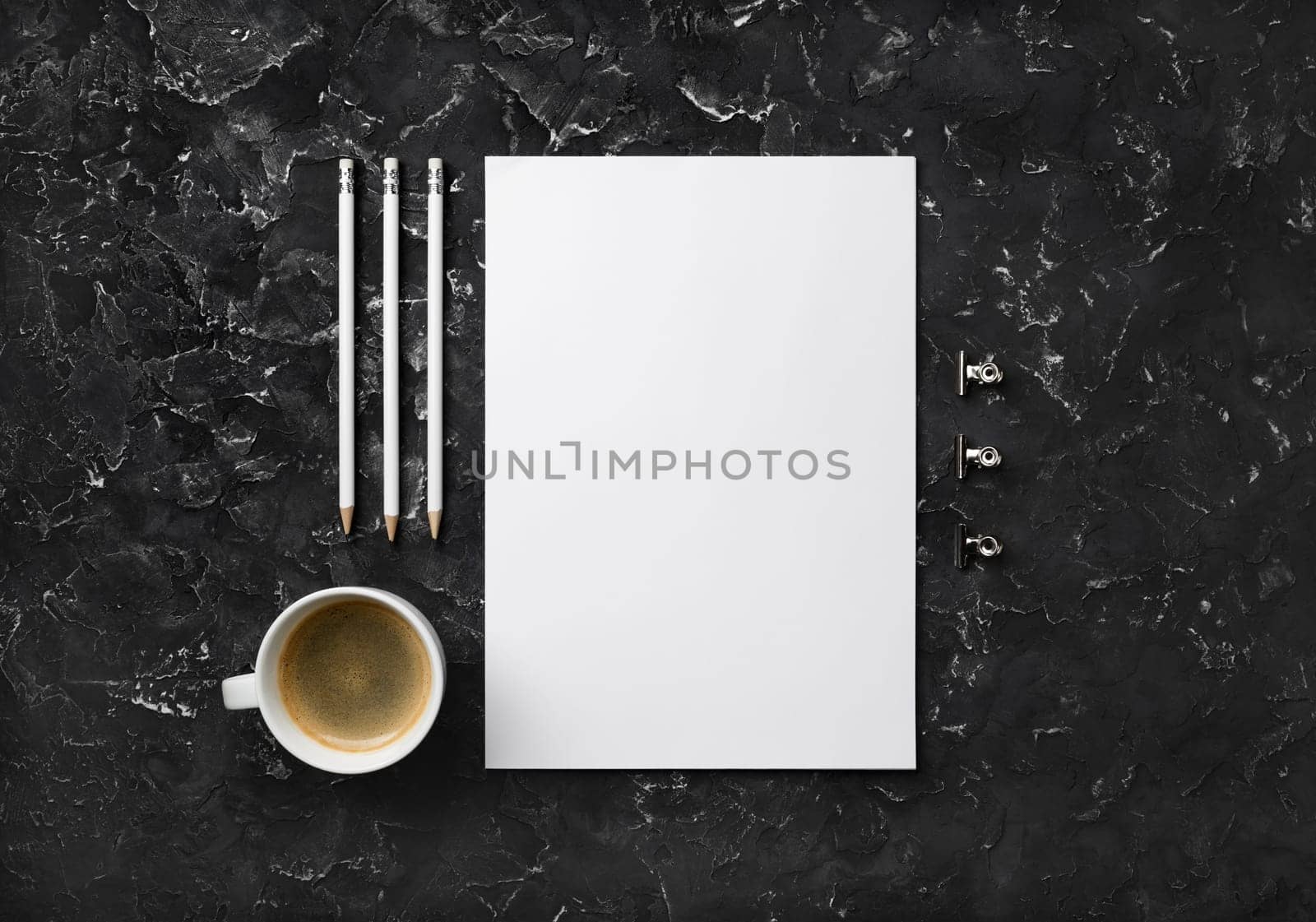 Blank letterhead, coffee cup and pencils on black plaster background. Top view with copy space. Flat lay.