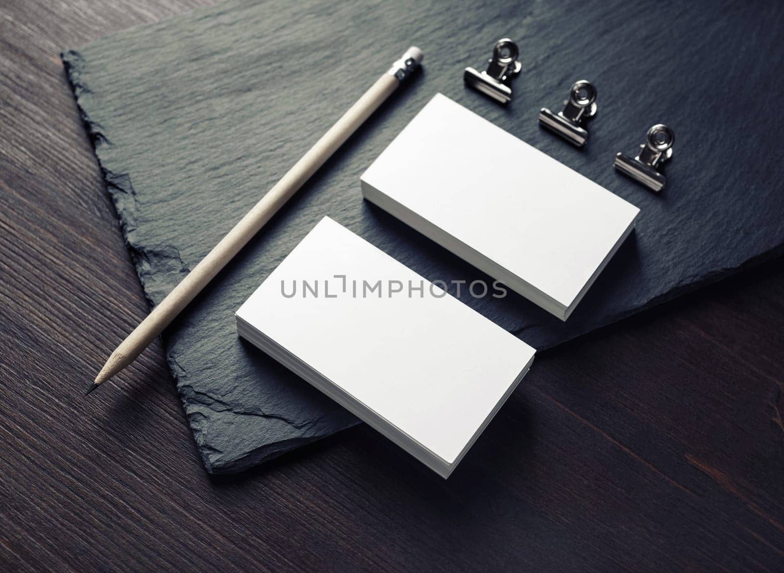 Photo of blank business cards, pencil and clips. Responsive design template.