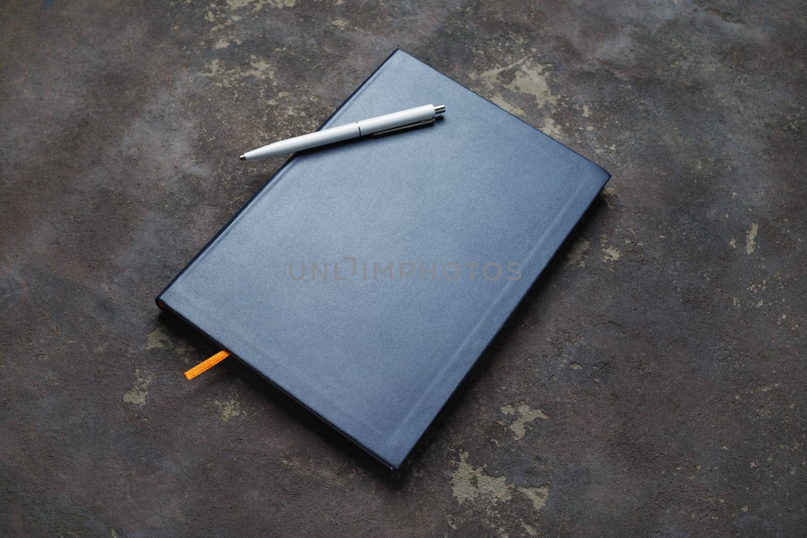 Notebook and pen on concrete background. Responsive design template.