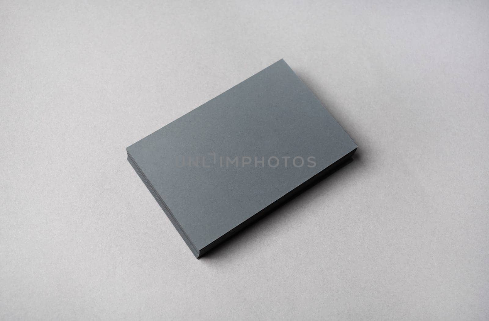 Photo of blank gray business cards on gray paper background. Template for ID.