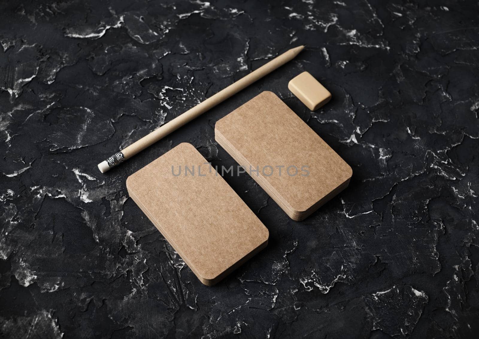 Blank kraft business cards, pencil and eraser on black plaster background. Mockup for branding identity.