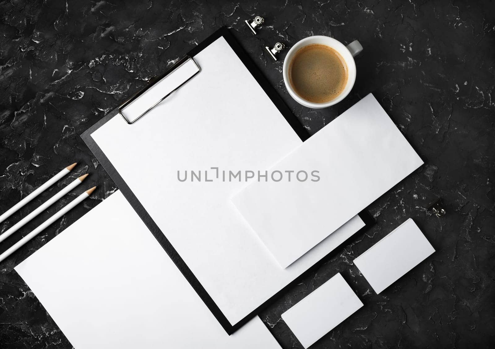 Photo of blank stationery set on black plaster background. Corporate identity mockup. Responsive design template. Top view. Flat lay.