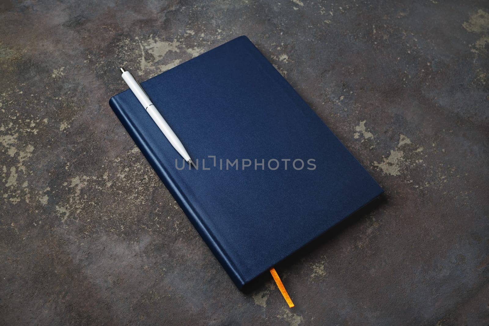 Blank notepad and pen on concrete background. Stationery elements. Template for placing your design.