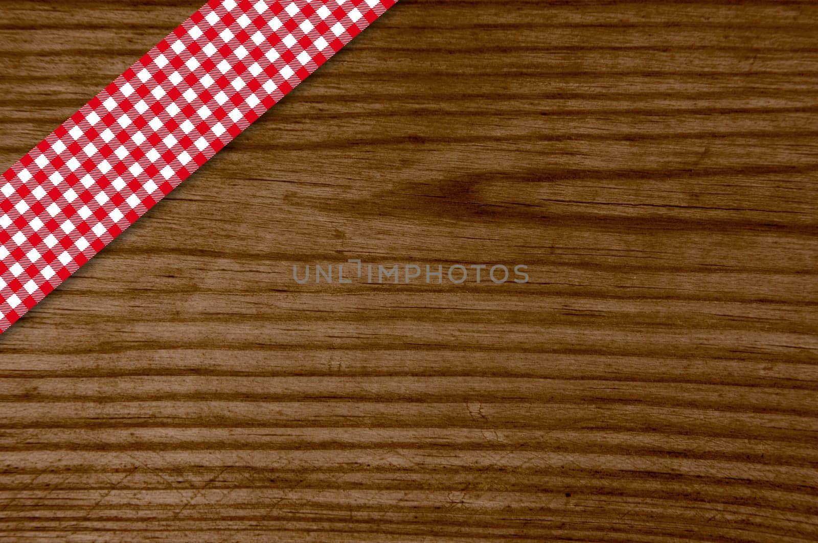Old wooden table with red white checkered tablecloth