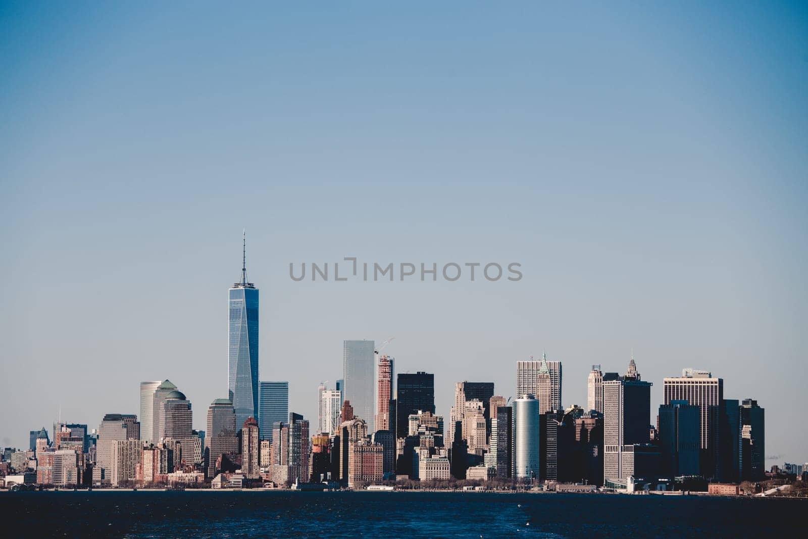 New York City Manhattan downtown skyline at dusk with skyscrapers illuminated over Hudson River panorama. Vertical composition.
