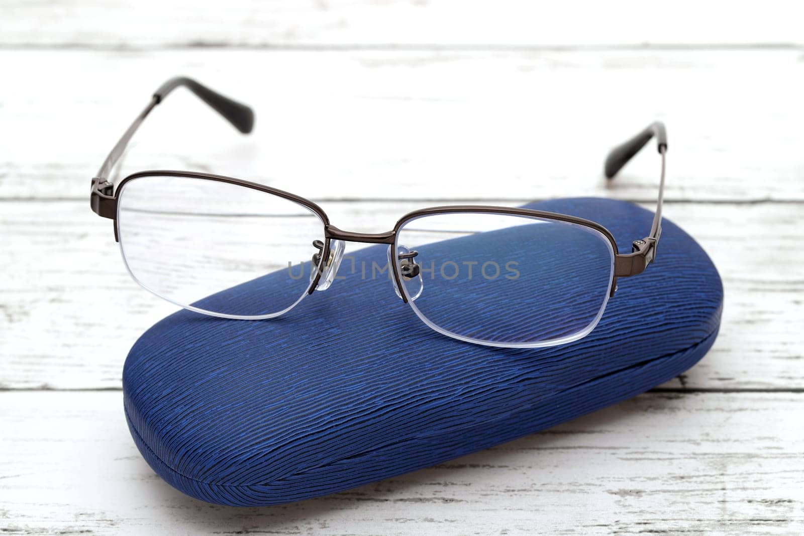 Stylish eyesight glasses and case for glasses on white wooden table