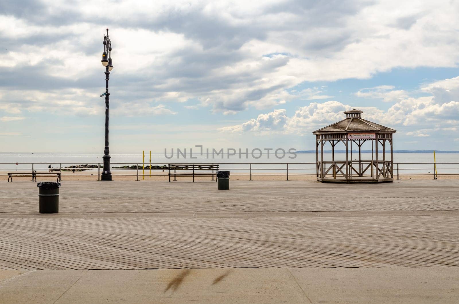 Empty Beach Promenade at Coney island, Brooklyn during sunset with ocean and cloudy Sky, Beach Pavilion at the Promenade, New York City during winter day with cloudy sky, horizontal