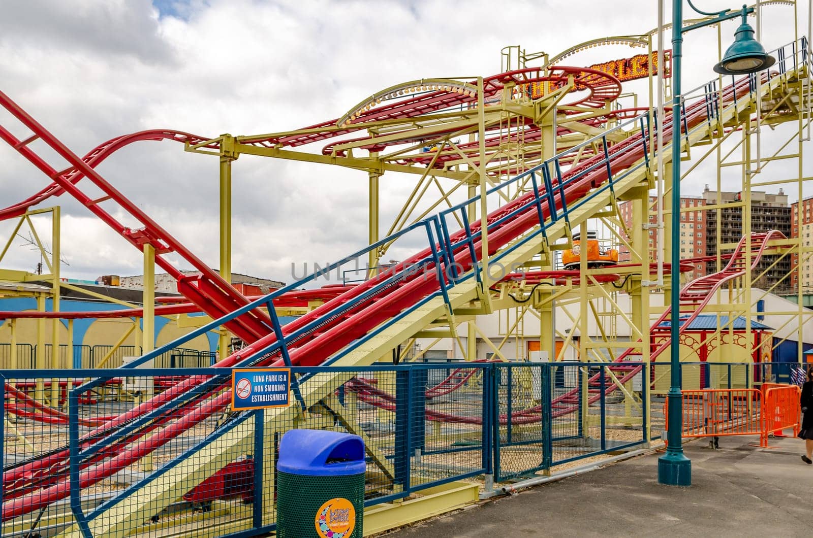 The Tickler Red Rollercoaster at Luna Park Amusement Park, view from the side, Coney island, Brooklyn, New York City during winter day with cloudy sky, horizontal