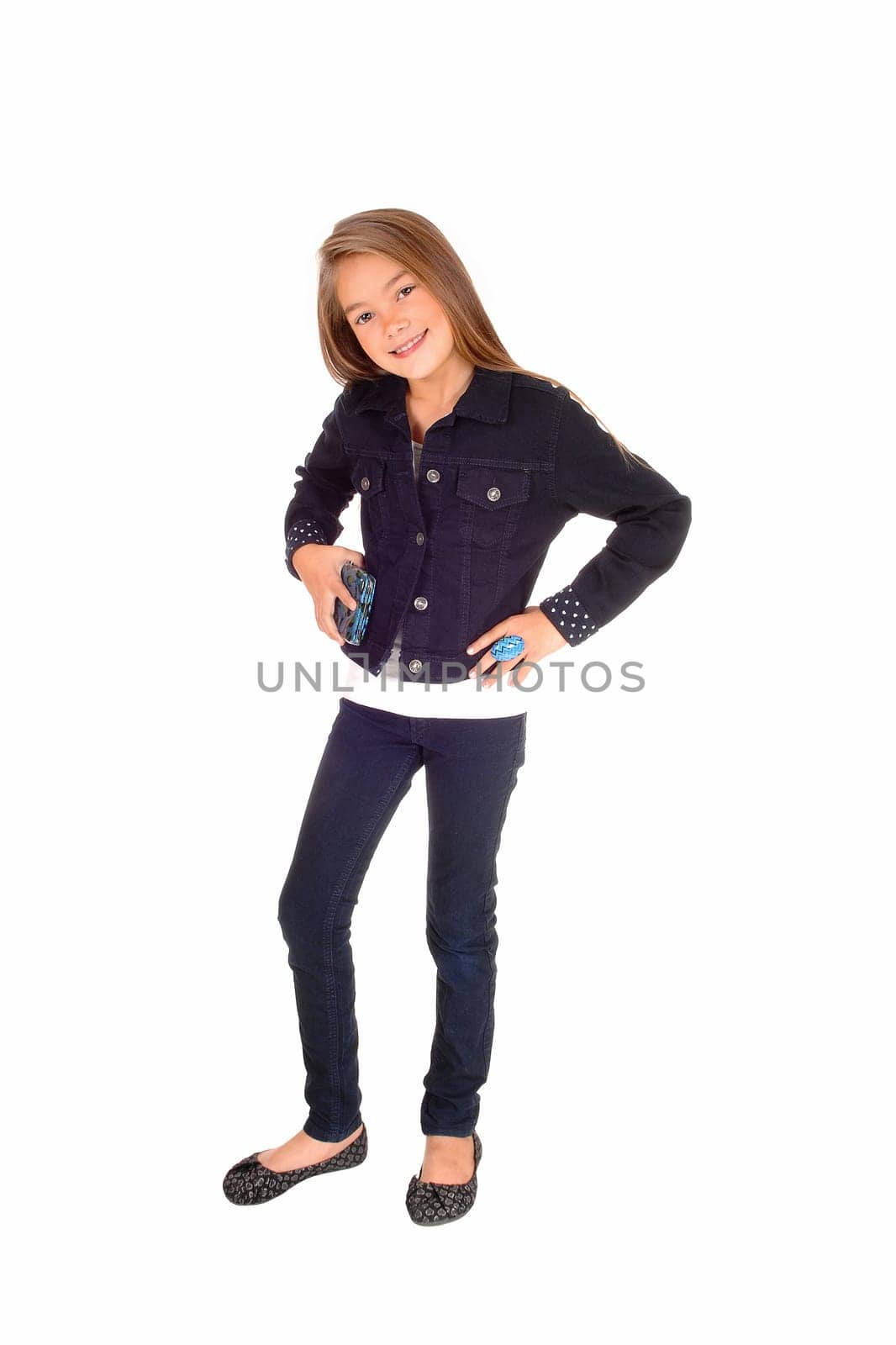 A pretty eight year old girl standing isolated for white background in jeans and.a jean jacket.