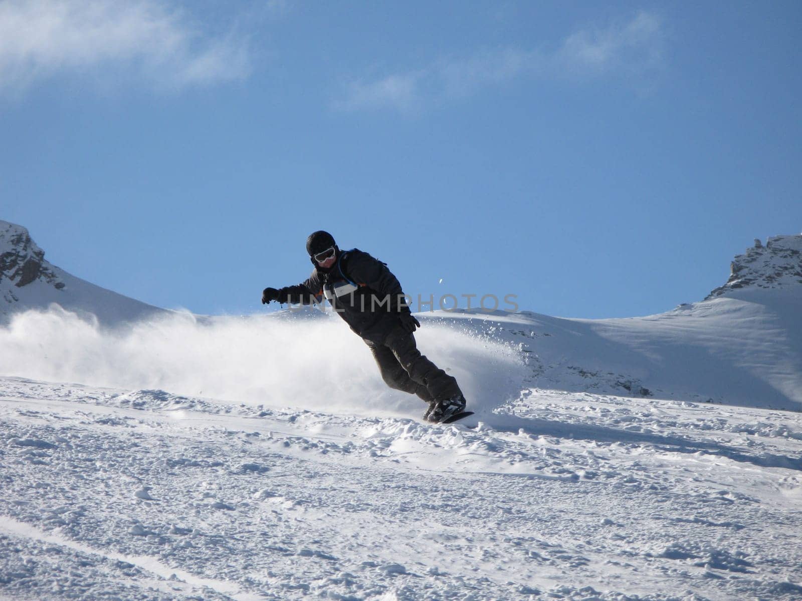 Snowboarder carving a turn on the piste