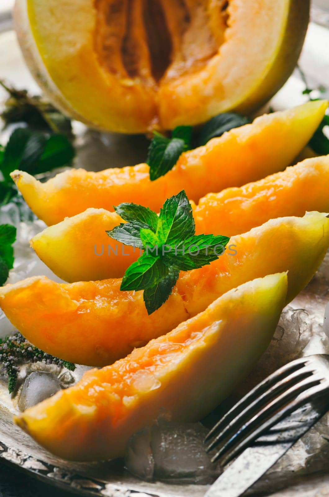 Melon slices on silver plate with mint