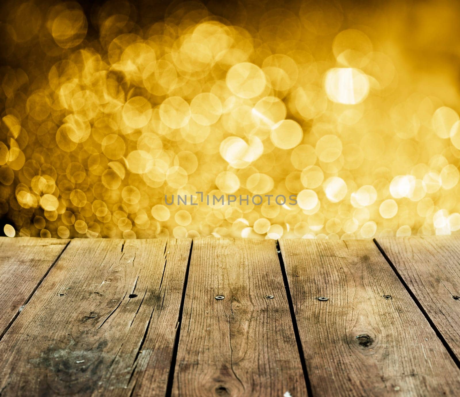 Empty wooden table with christmas lights behind.