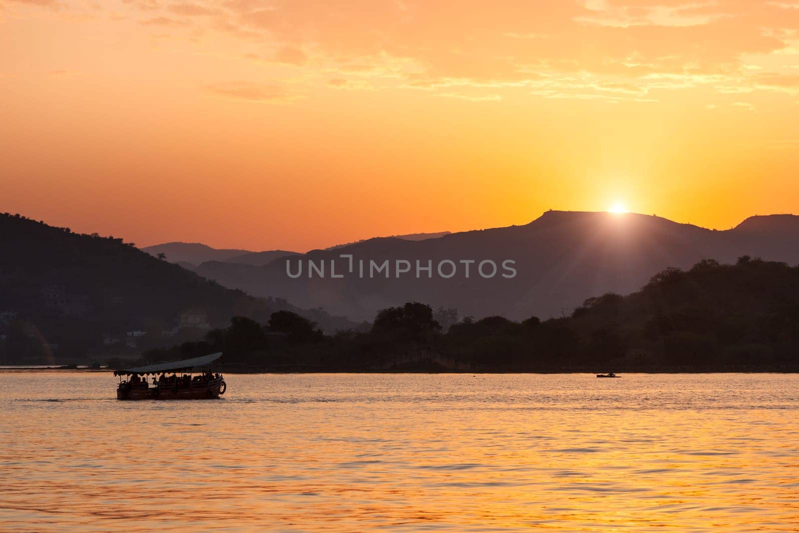 Tourist boat in lake Pichola on sunset. Udaipur, Rajasthan, India