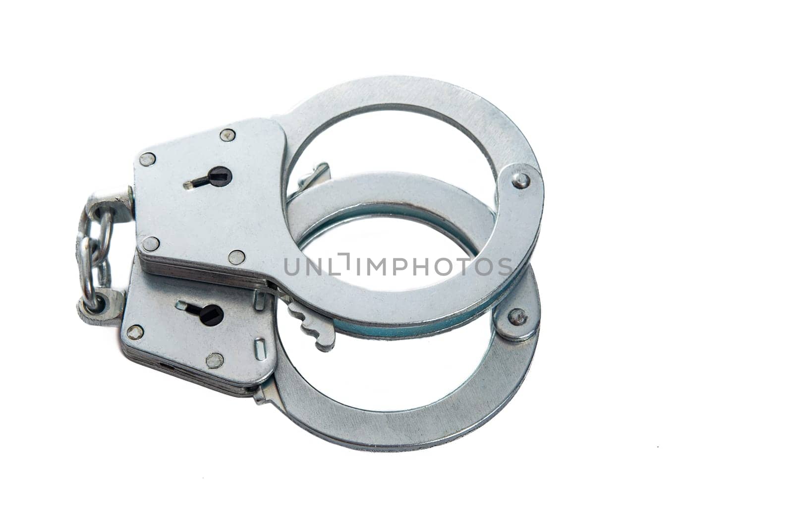 Metal handcuffs on a white isolated background, copy space. High quality photo